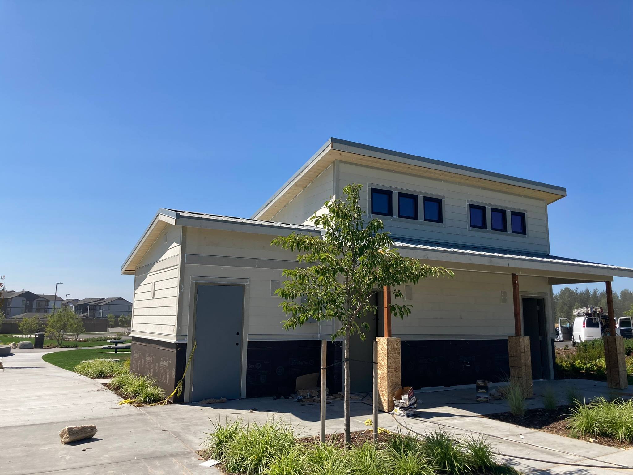 Modern shed-roof home with cream lap siding, a dark base band, and clerestory windows